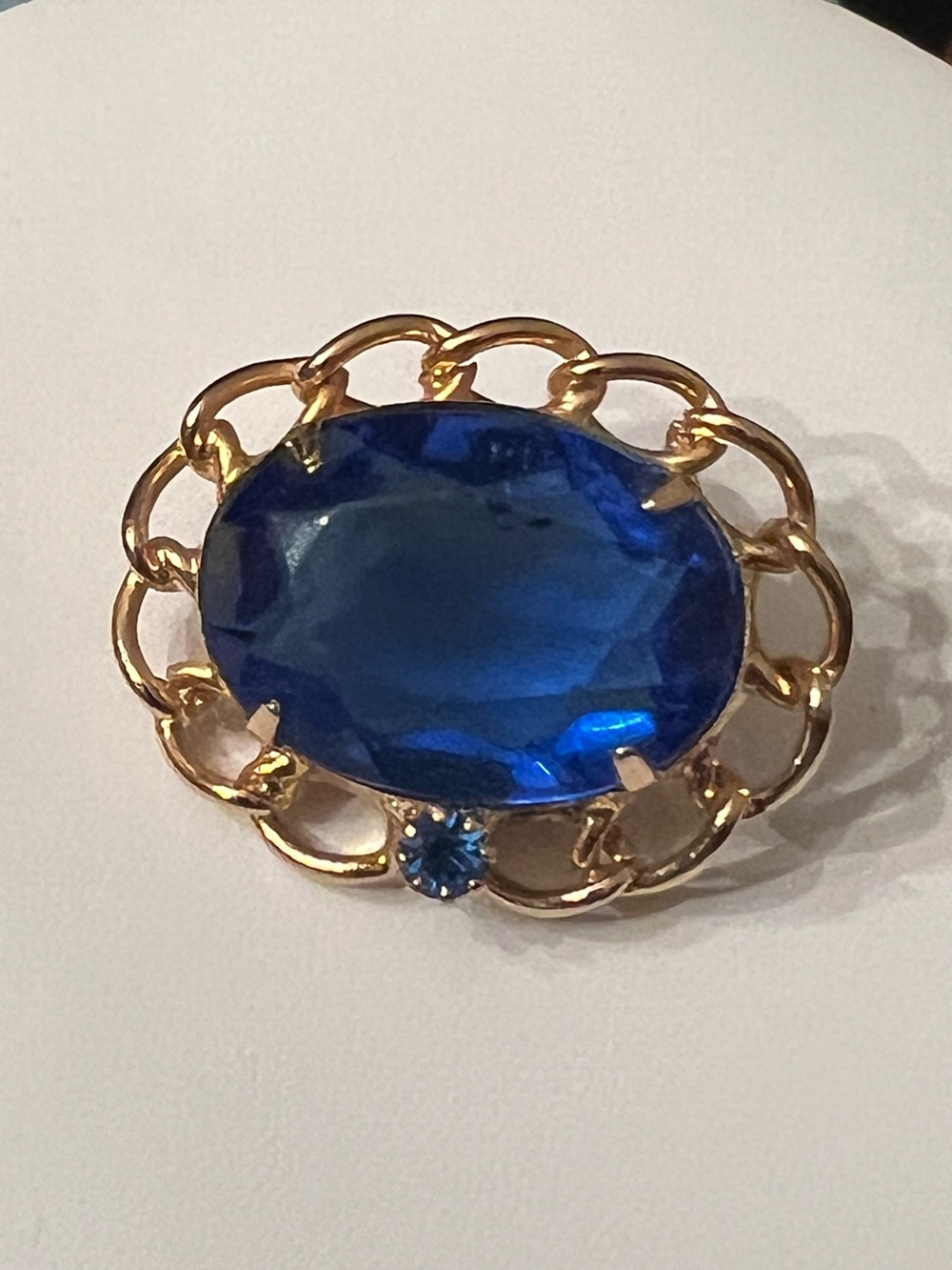 Vintage royal blue oval faceted glass stone brooch in gold tone chain setting